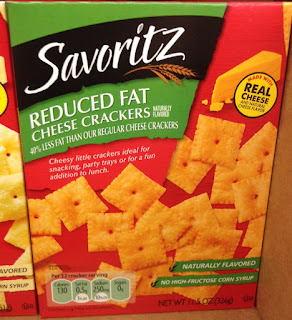 A box of Savoritz Reduced Fat Cheese Baked Snack Crackers, sitting on an Aldi shelf